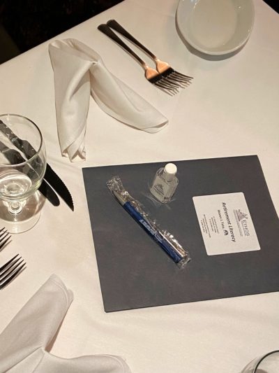 table setting with folder, pen, sanitizer